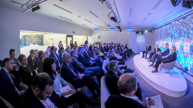 An audience listening to a panel on stage